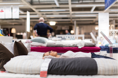 Femme couchée dans un lit dans un magasin de literie.